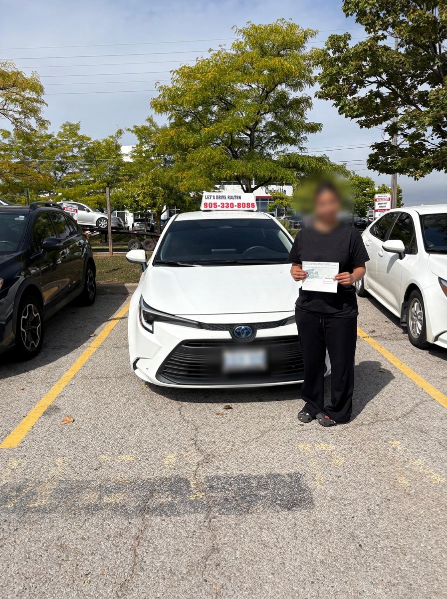 Successful student with a certificate beside the Let’s Drive Halton car